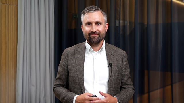 Person præsenterer investeringskommentar.