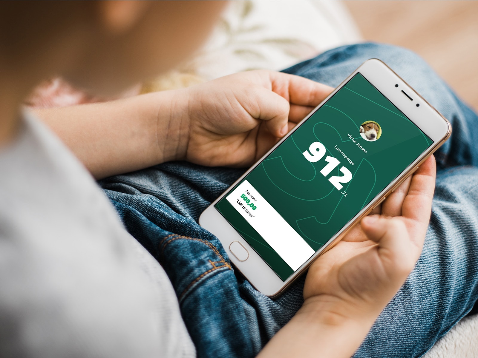 Billede af dreng der holder mobil med Juniorbank appen på skærmen – mobilbank for vores yngste kunde