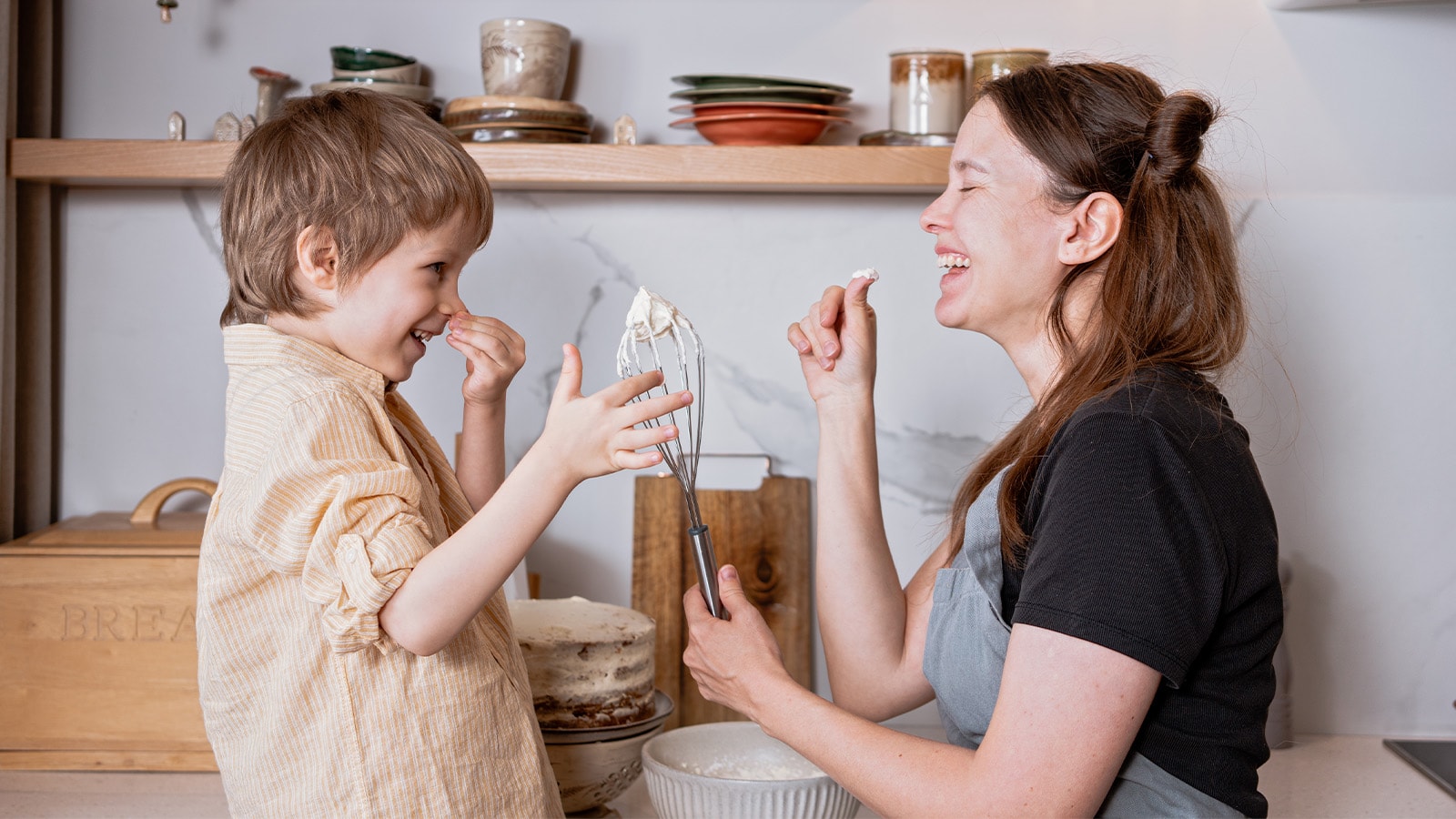 Mor og søn bager kage i køkken
