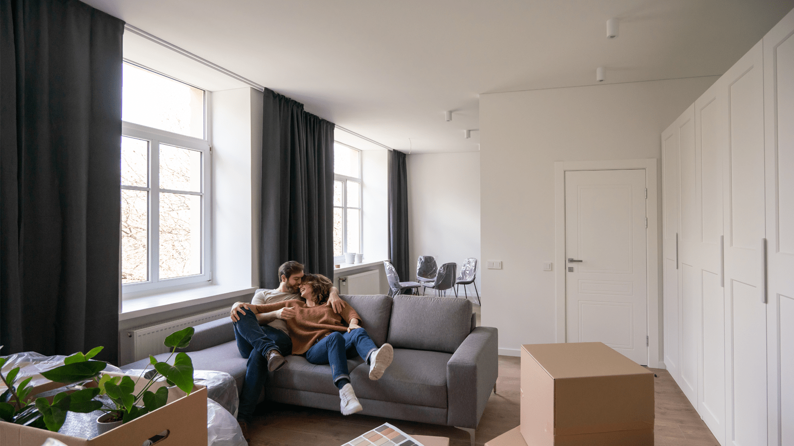 Par i lejlighed med flyttekasser overalt, sidder i sofa og er klar til at flytte