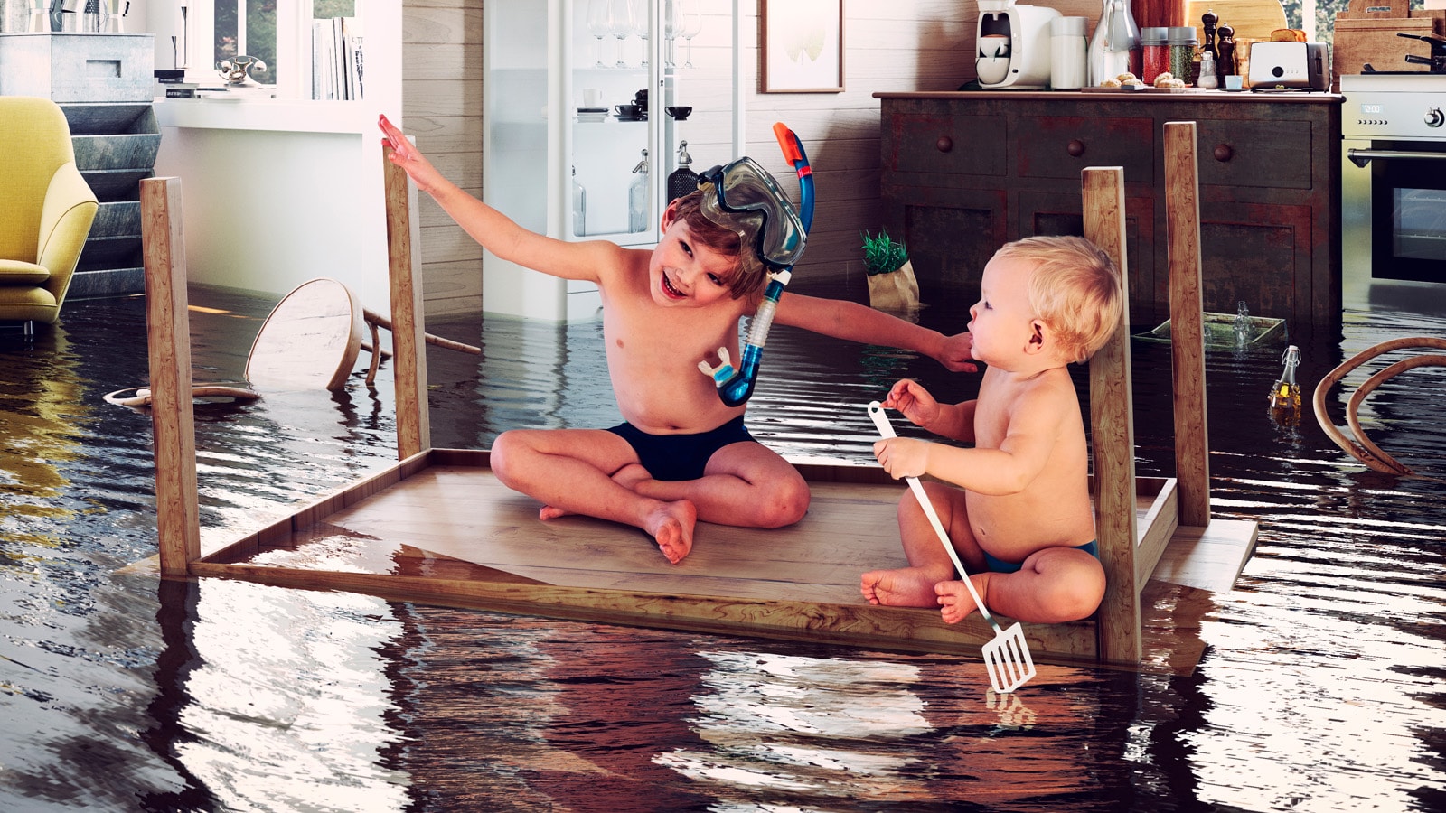 To børn i oversvømmet hjem hygger sig på et bord der er vendt på hovedet. De sejler.