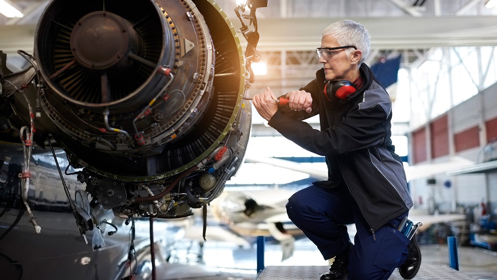 Ældre mekaniker skruer i en maskine