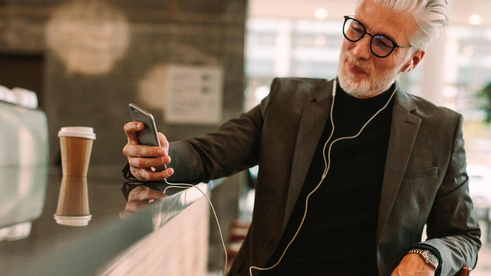 Mand på cafe med mobiltelefon tager selfie