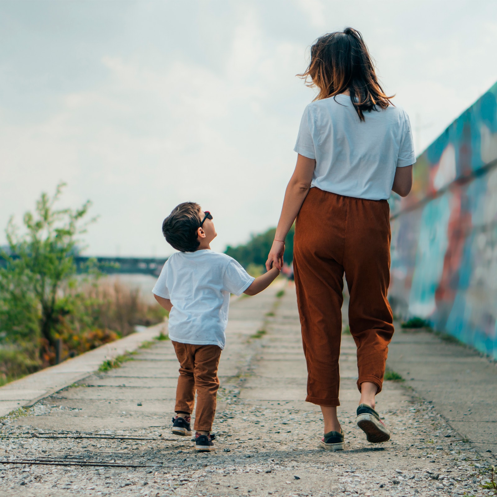 mor og søn holder i hånd på havnen og går en tur