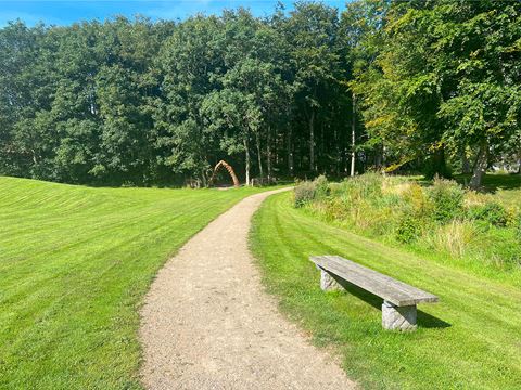 Højskoleengen Røddingi dejlig sommerdag med grønt græs og grønne træer og blå himmel