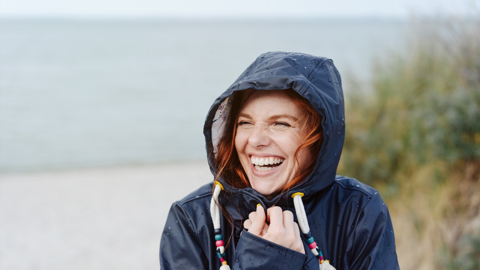 Pige ved vestkysten i regntøj 